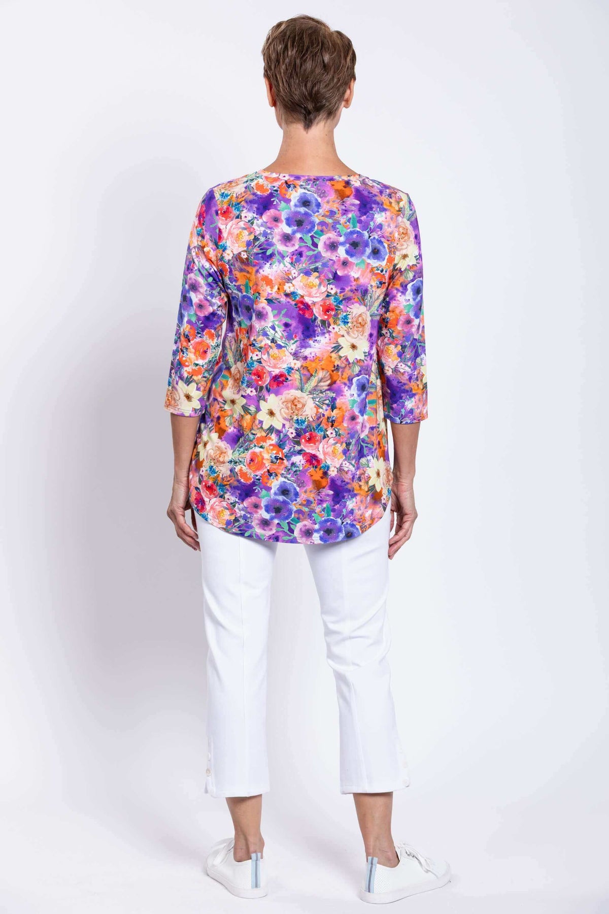 Back view of a vibrant floral bamboo top with rounded hemline worn by a woman