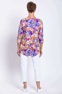 Back view of a vibrant floral bamboo top with rounded hemline worn by a woman