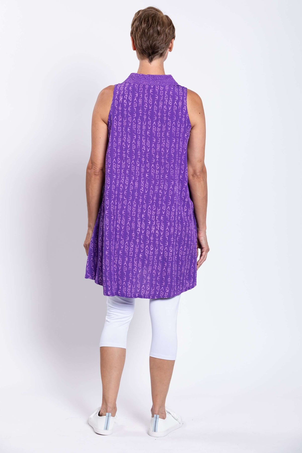 Rear view of woman wearing violet sleeveless tunic top showing a loose fit and pattern