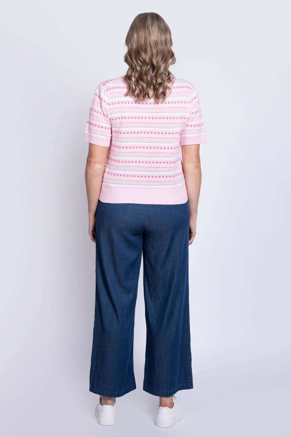 Back view of woman wearing the Danny Sweater in pink with patterned detailing