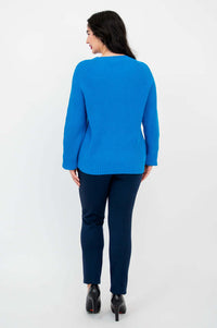 Back view of blue slouchy knit sweater paired with navy pants and black heels