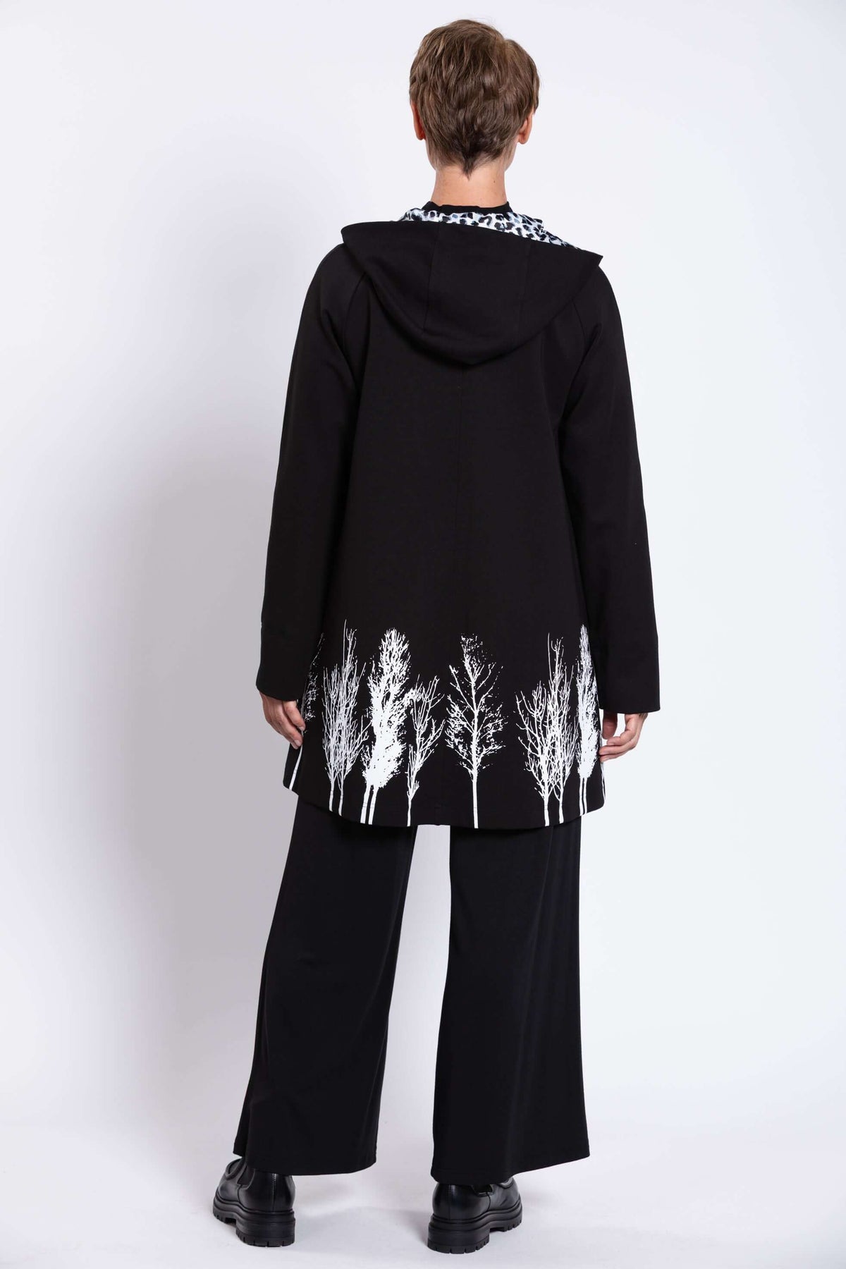 Back view of Edith Coat with hood and bold white tree border pattern