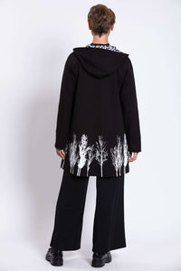 Back view of Edith Coat with hood and bold white tree border pattern