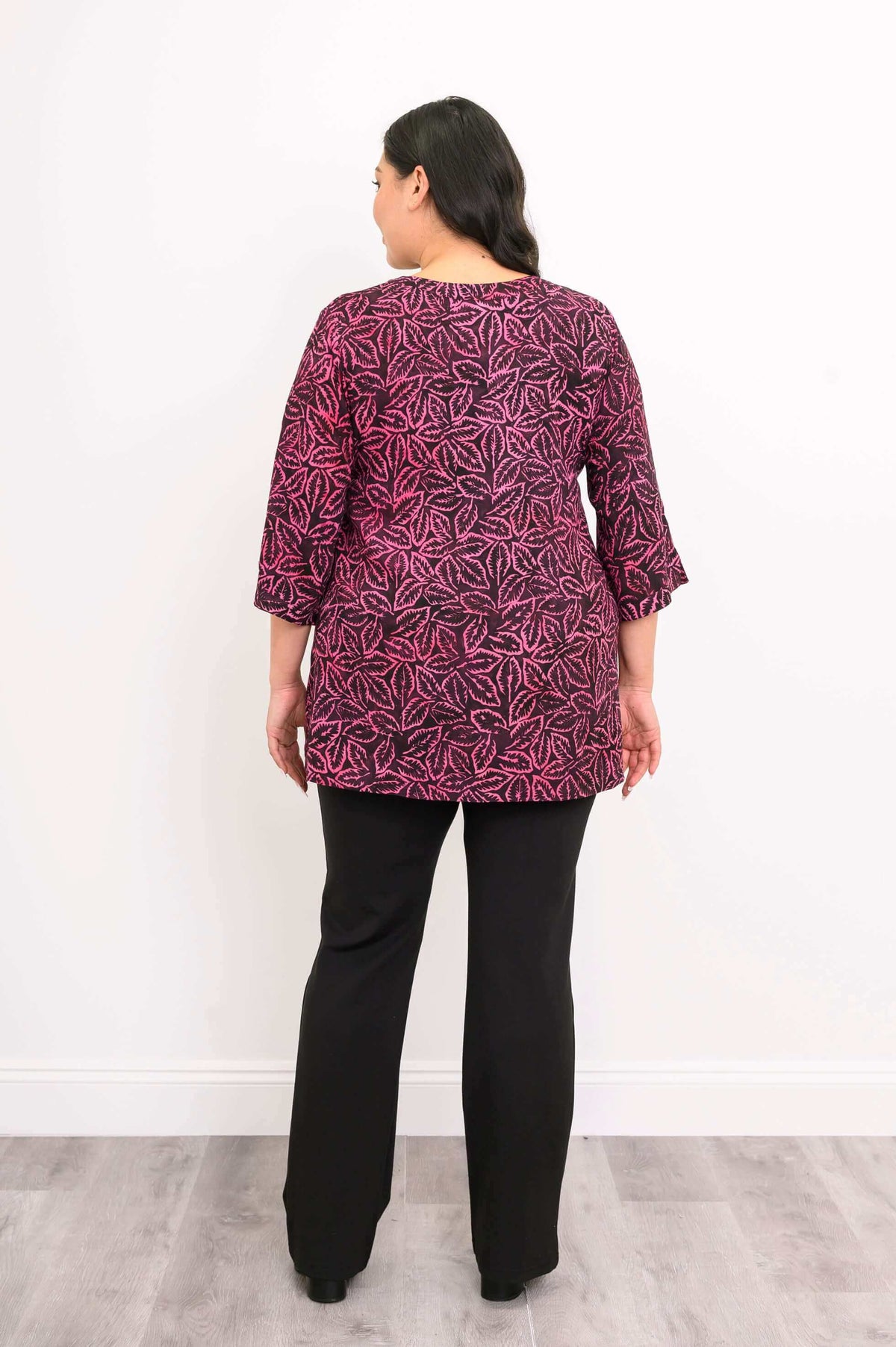 Back view of woman wearing Evelyn Top in pink and black leaf print