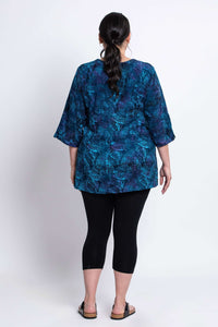 Back view of Evelyn Top lagoon blue, showing flowy silhouette and patterned fabric