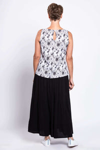 Back view of a woman in a black and white floral tank top showing the button closure