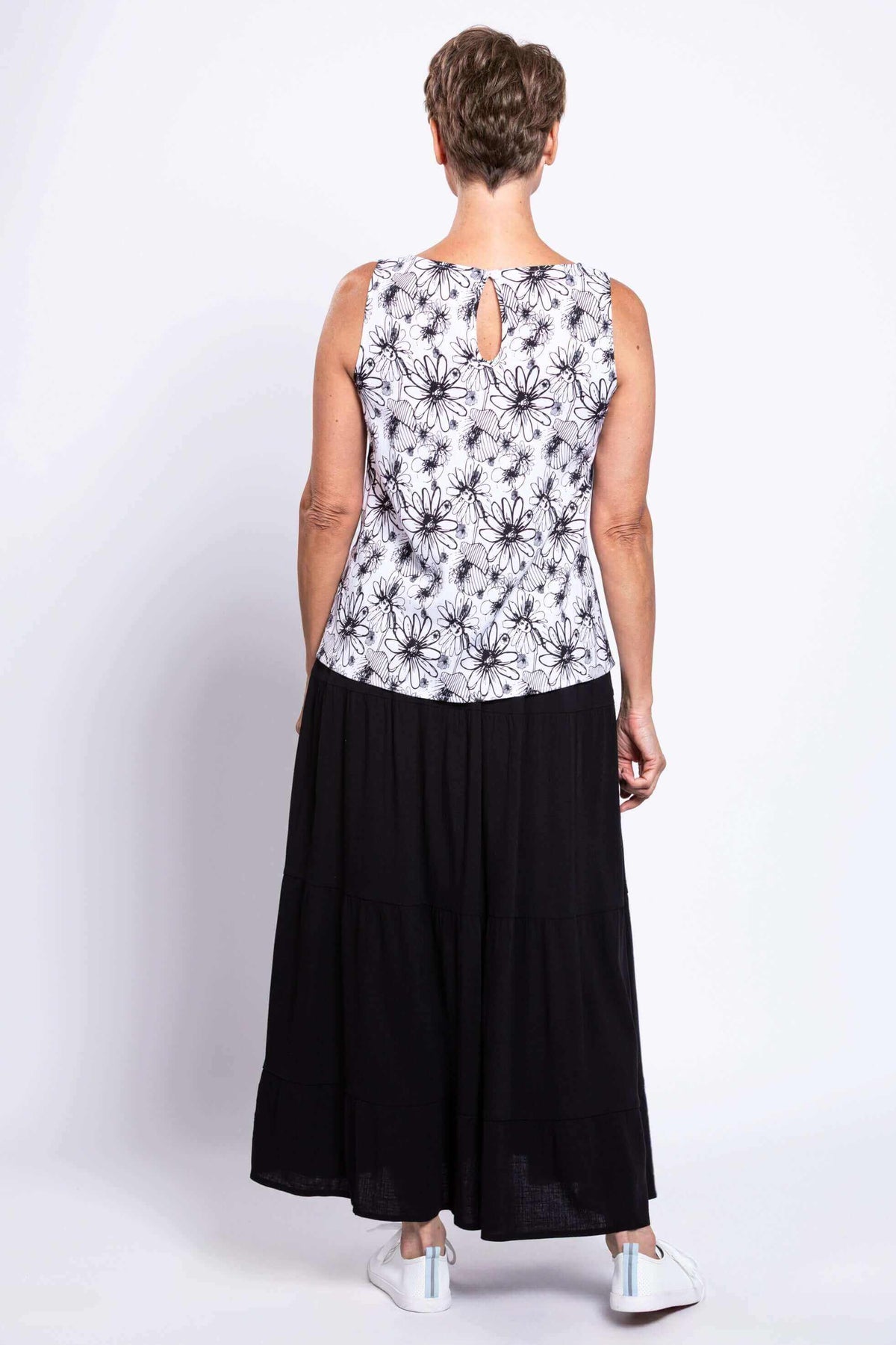 Back view of woman wearing a sleeveless floral tank top with button closure