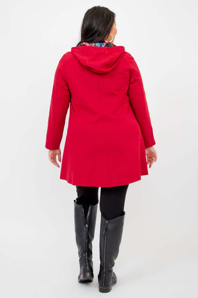 Back view of a person wearing a berry red swing coat with a hood