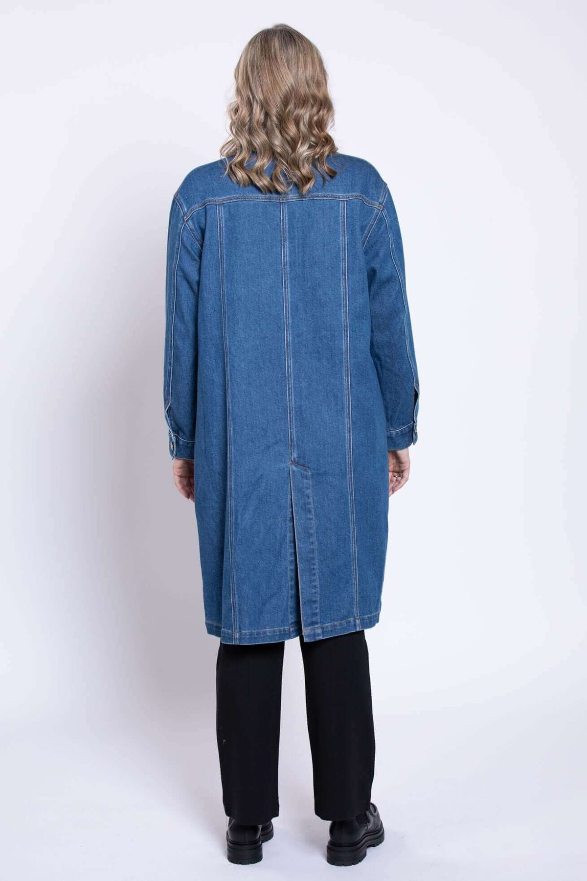 Back view of woman wearing a longline blue denim jacket
