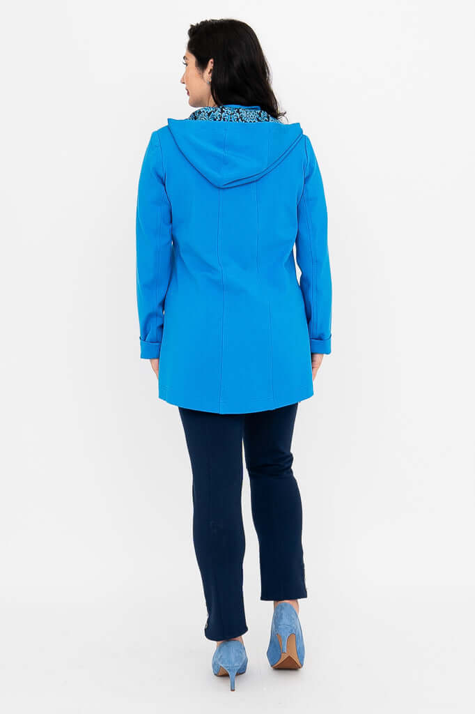 Back view of blue hooded coat with patterned lining, worn by woman