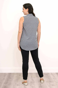 Back view of a woman in a black and white gingham tank top and black pants