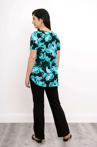 Back view of woman modeling short sleeve blouse with neon turquoise swirl print
