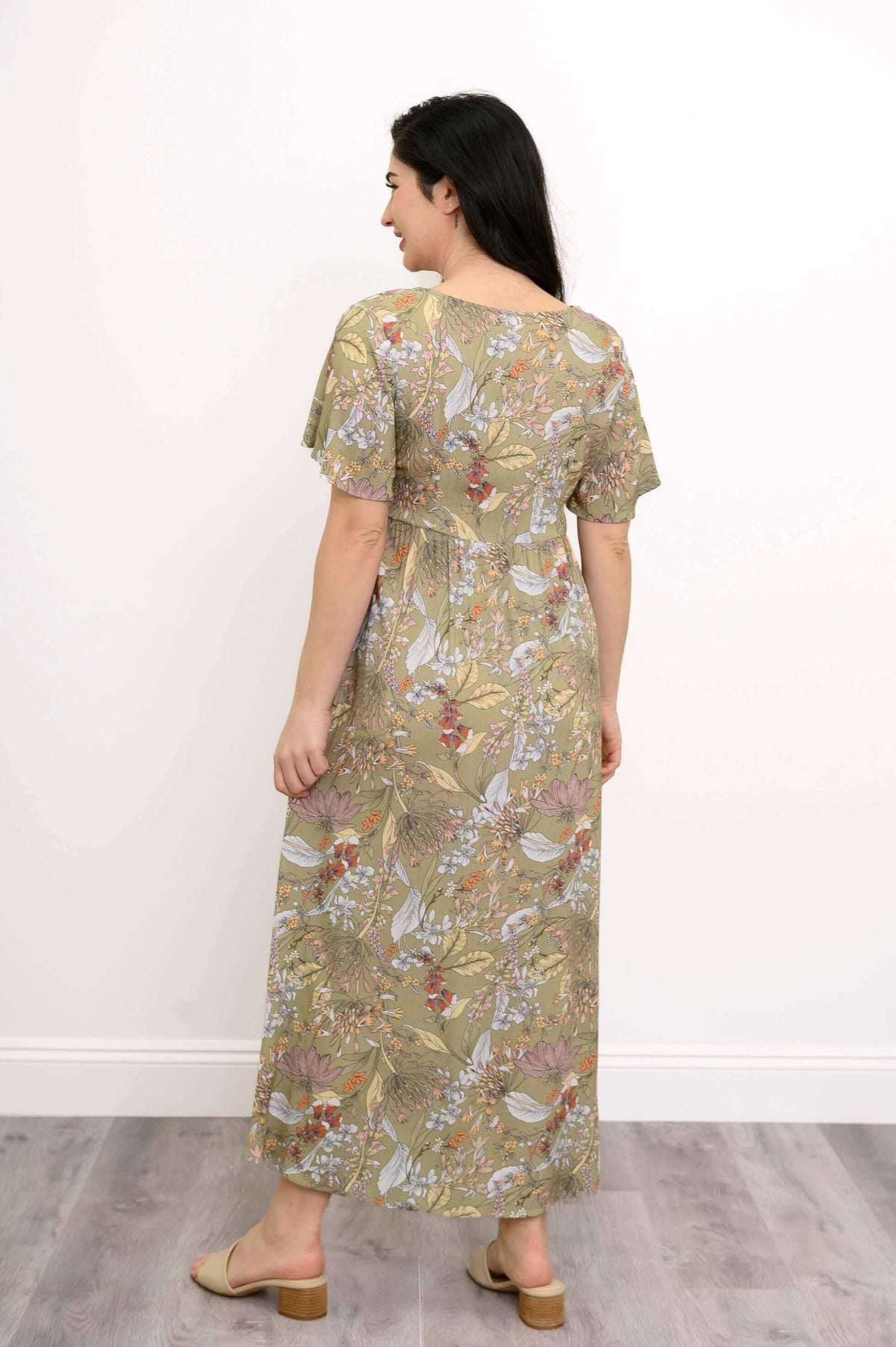 Back view of woman wearing green floral empire waist maxi dress