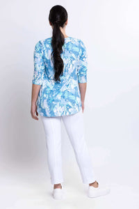 Back view of woman wearing blue watercolor bamboo top and white pants