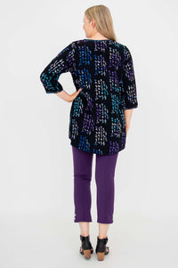 Back view of a woman wearing the Batik Kary Blouse and purple pants