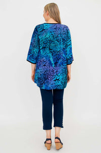 Back view of woman wearing the blue and purple batik print blouse and navy pants