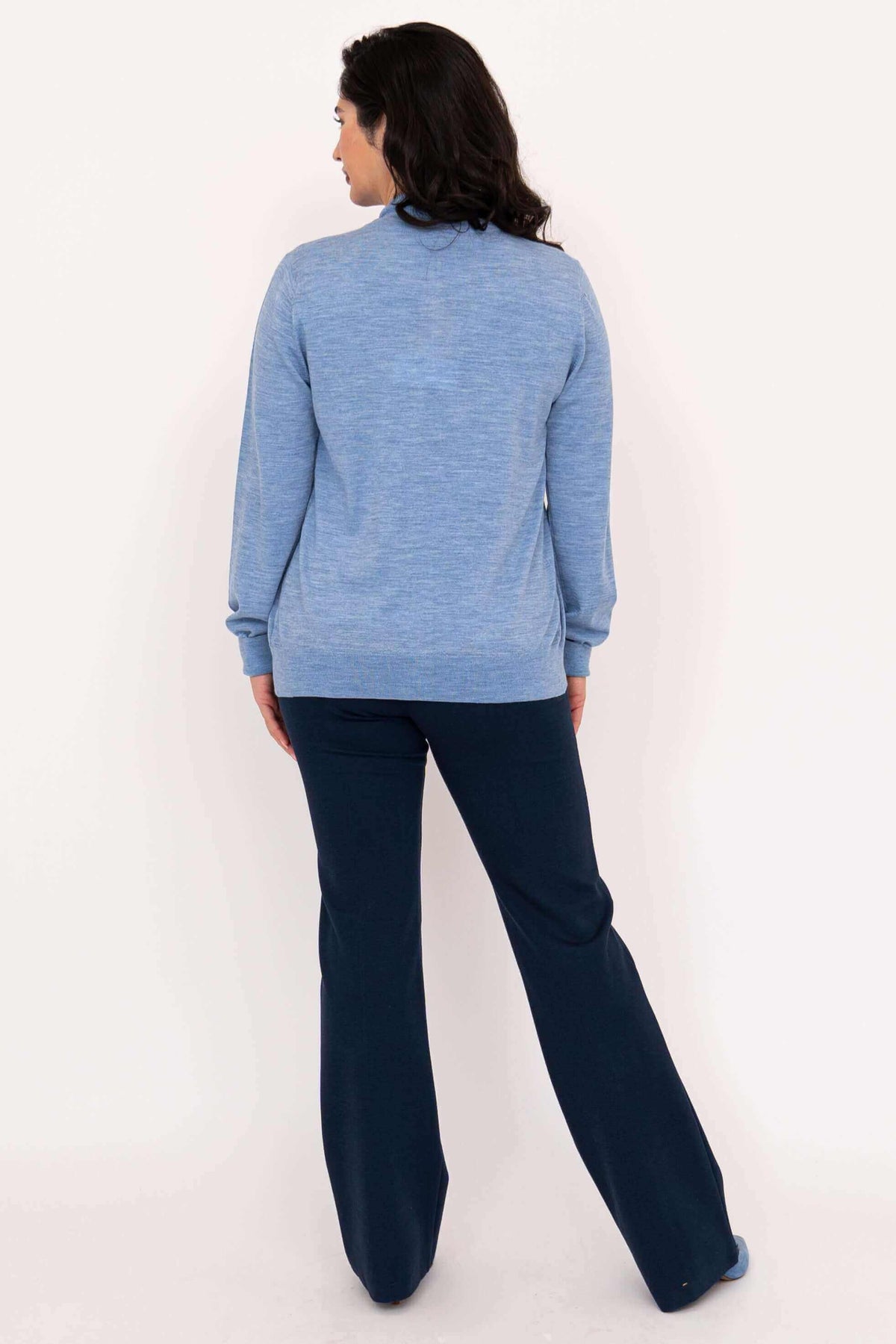 Back view of woman wearing light blue Merino wool button-up cardigan