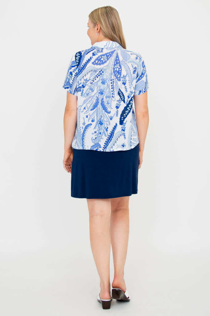Back view of a woman wearing the blue paisley Lala top and a navy skirt