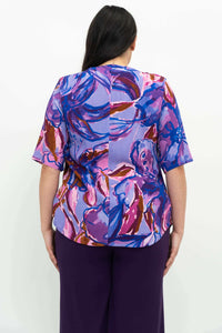 Back view of a woman wearing the Liza Water Iris floral blouse