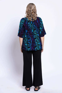Back view of a woman wearing a Luna Boho Peasant Top with floral blue and purple pattern
