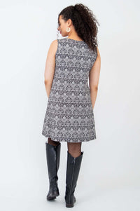 Back view of model in sleeveless shift dress showcasing allover patterned fabric and A-line cut