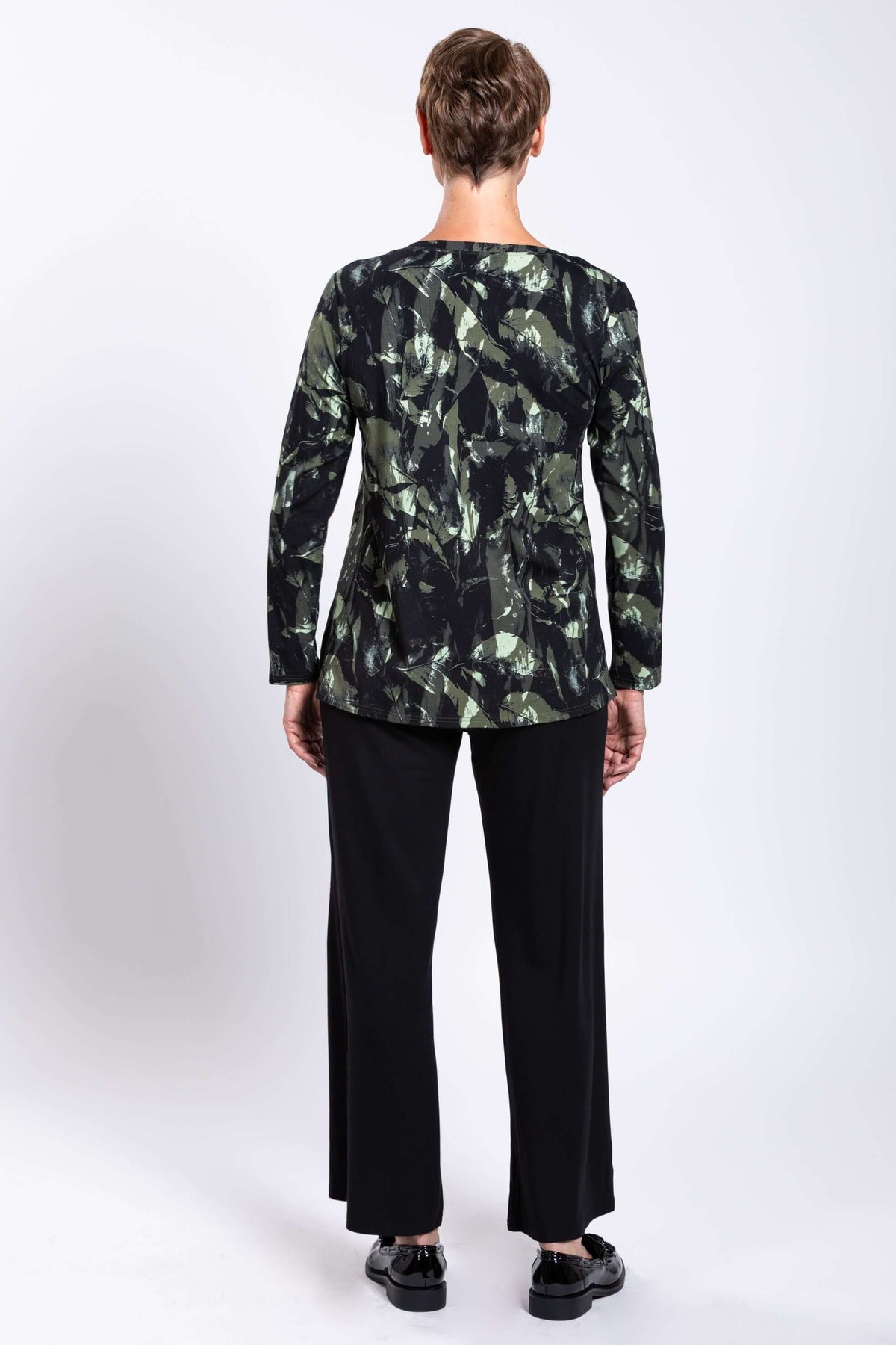 Rear view of a woman wearing a bamboo print long sleeve top with black pants