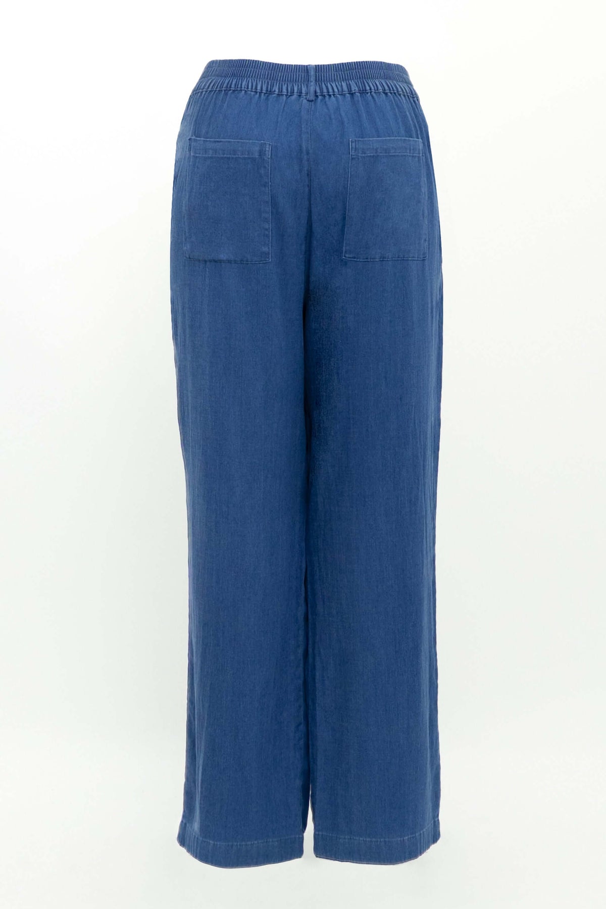 Back view of tencel denim pants displayed on a white background highlighting elastic waistband and pockets