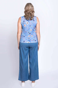 Back view of woman in blue floral cotton tank top and blue denim pants