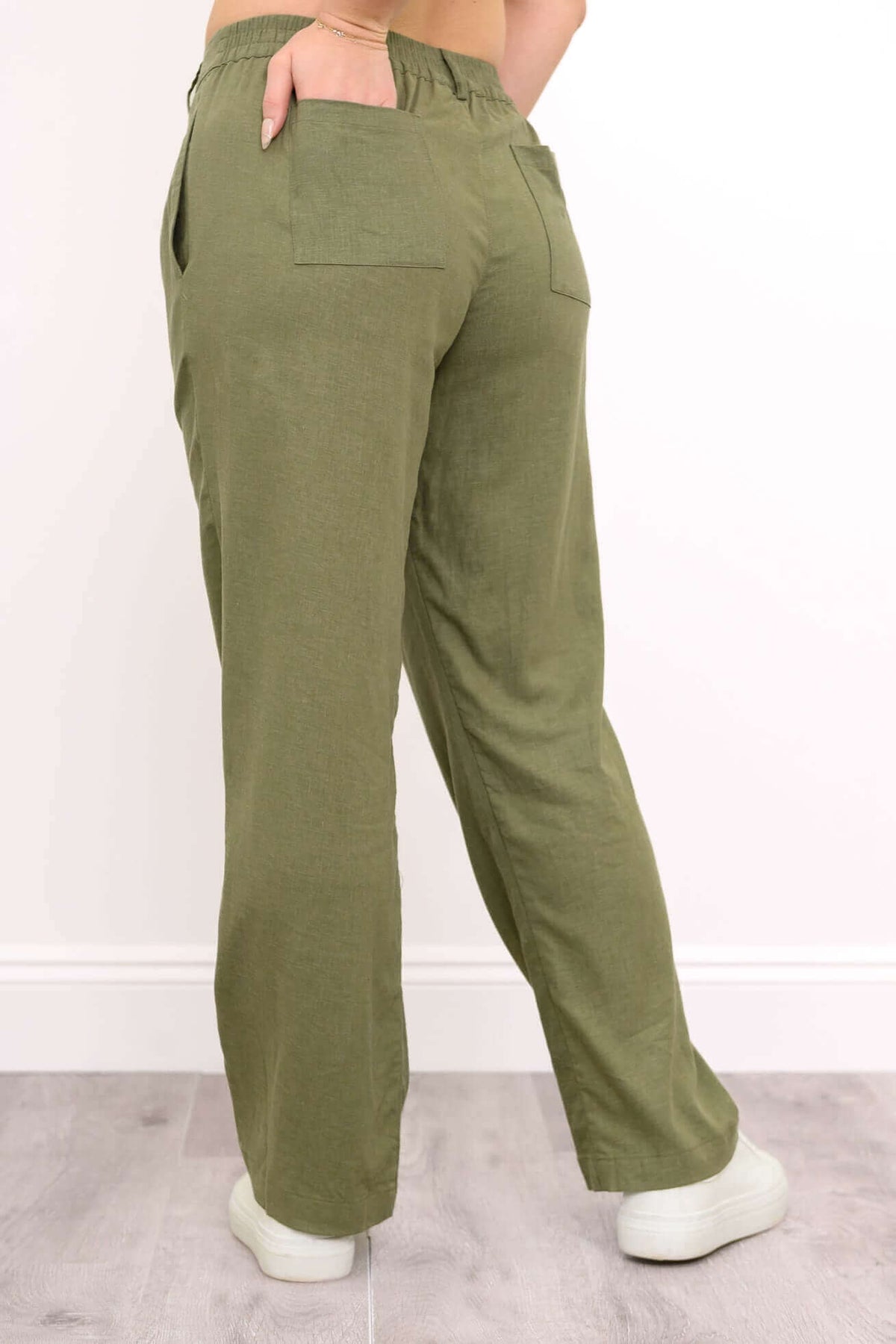 Back view of olive green pants highlighting elastic waistband and back pockets