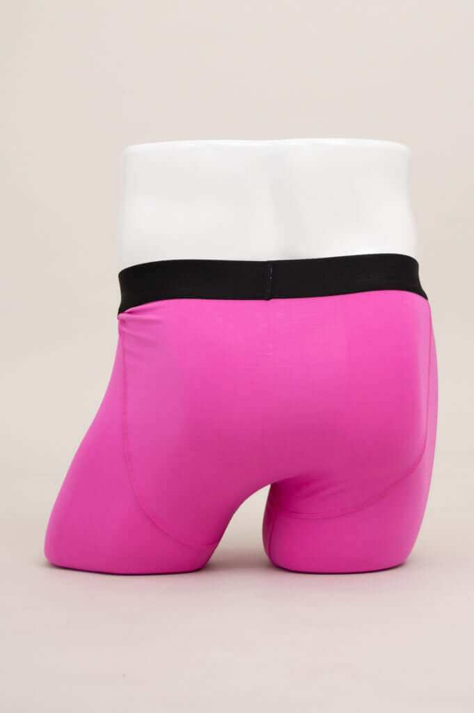 Rear view of hot pink boxer briefs with black waistband on mannequin