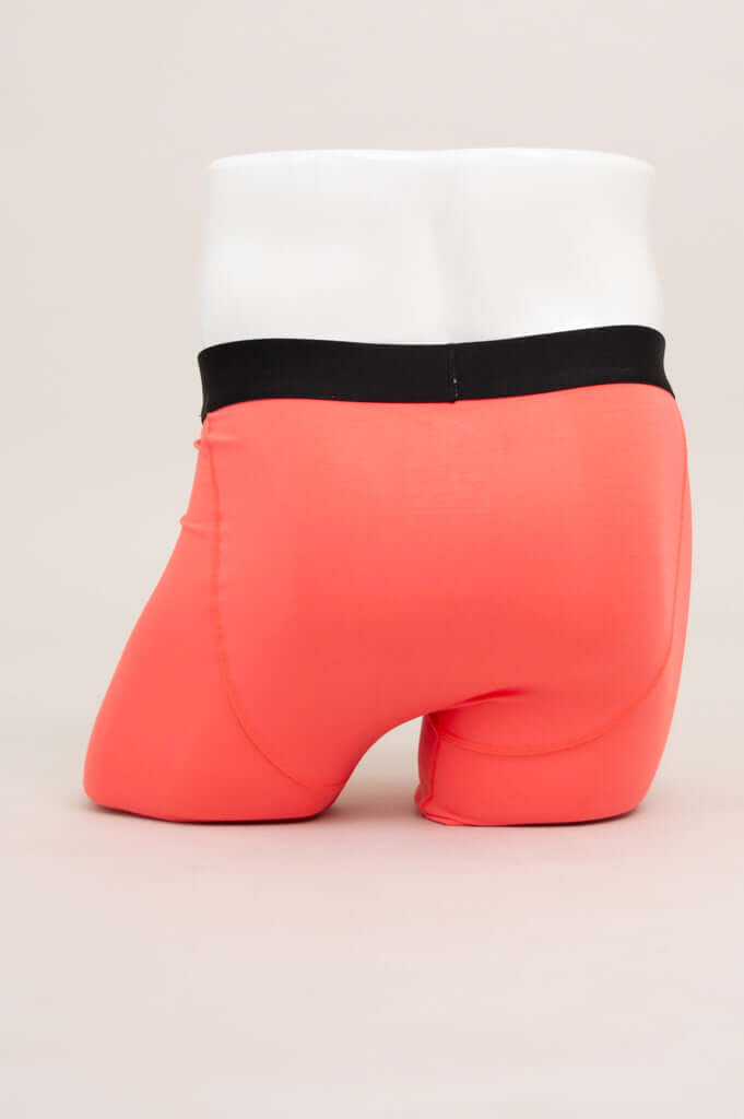 Rear view of coral men's boxer briefs with black waistband shown on mannequin