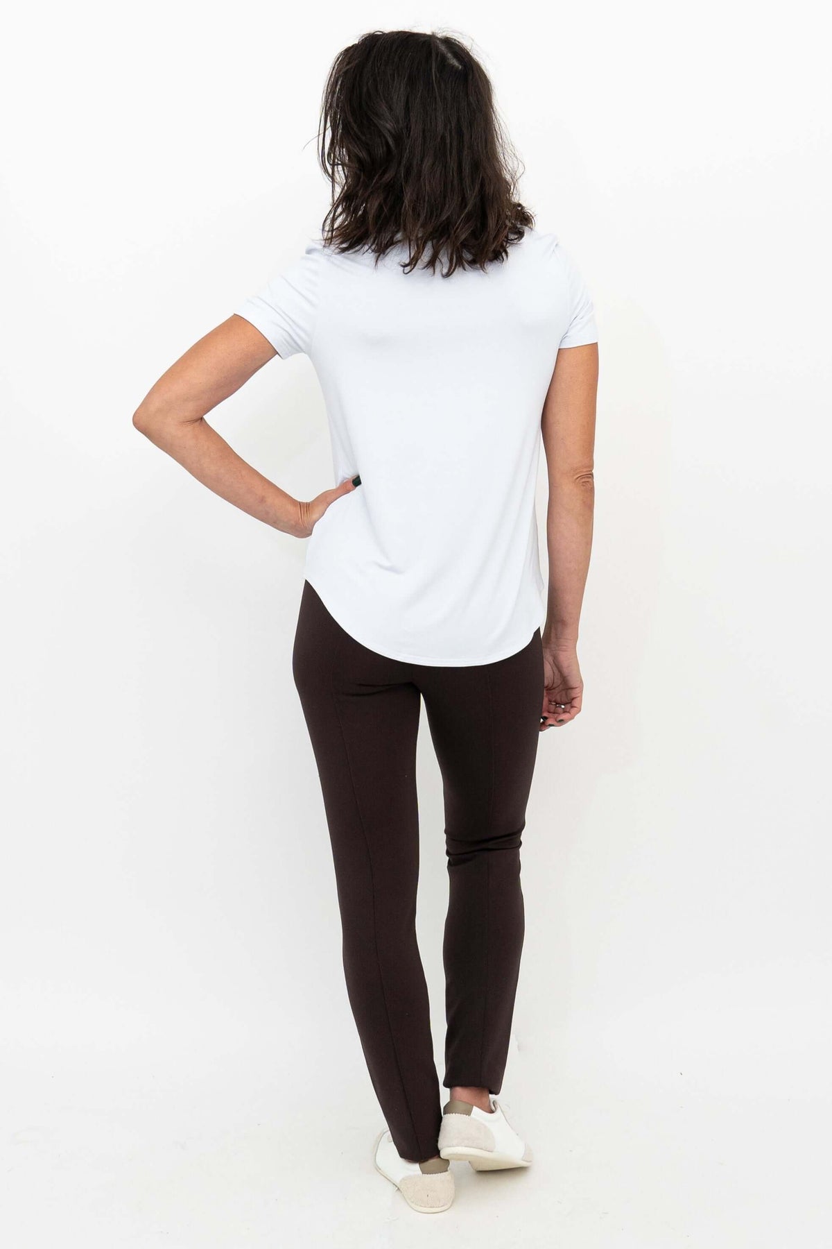 Back view of woman in Nadia slim-line brown pants with white top