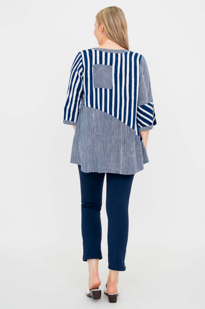 Back view of woman wearing navy and white striped blouse with block pattern and back pocket detail