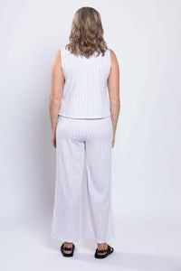 Back view of woman in white sleeveless striped top and pants set