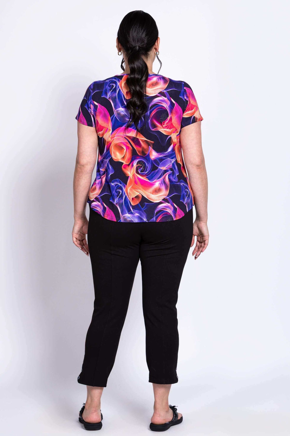 Back view of Ritzy Short Sleeve Top highlighting rounded hem and bright pattern