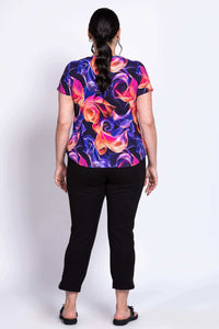 Back view of Ritzy Short Sleeve Top highlighting rounded hem and bright pattern