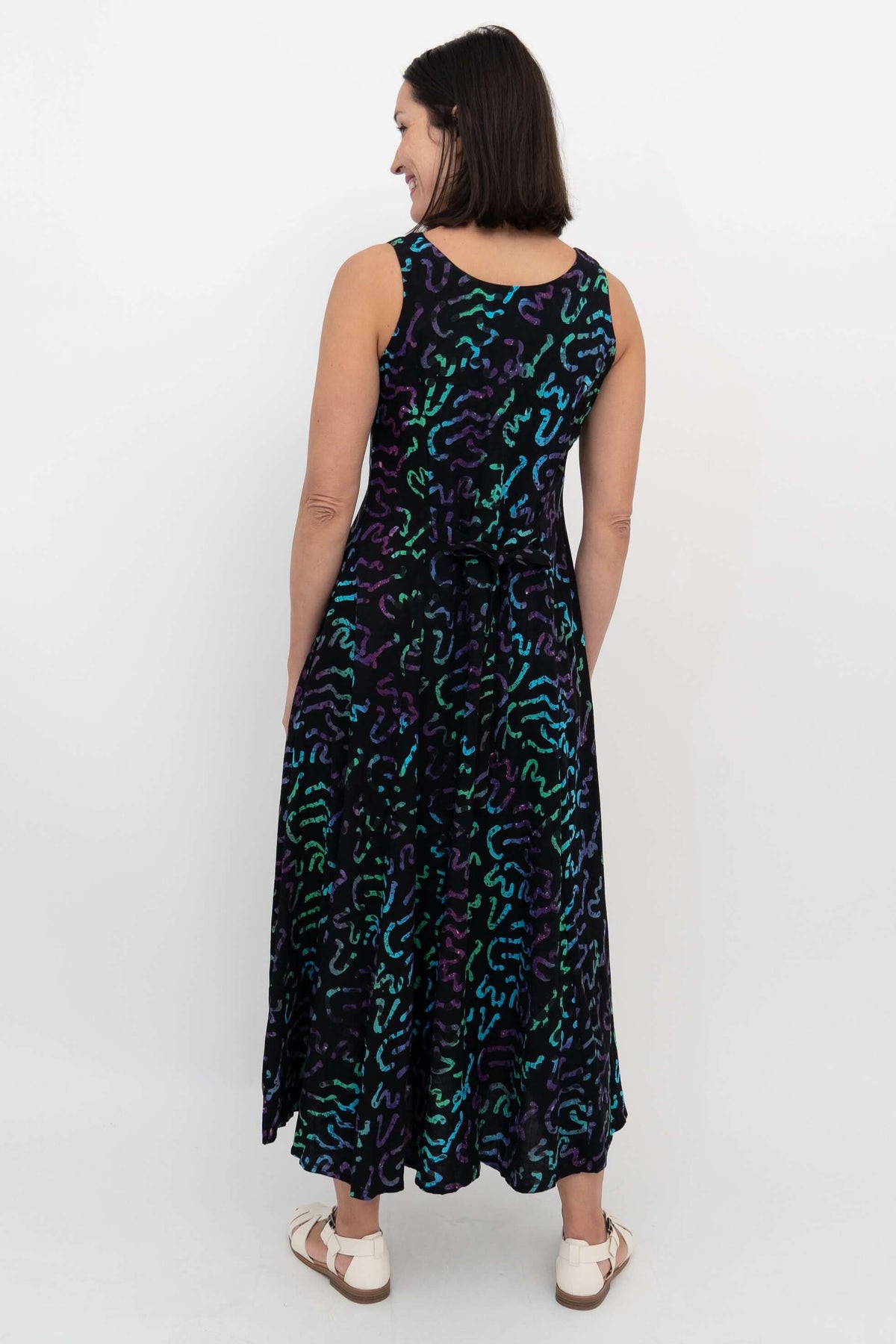 Back view showing tie waist and vibrant abstract pattern on maxi dress