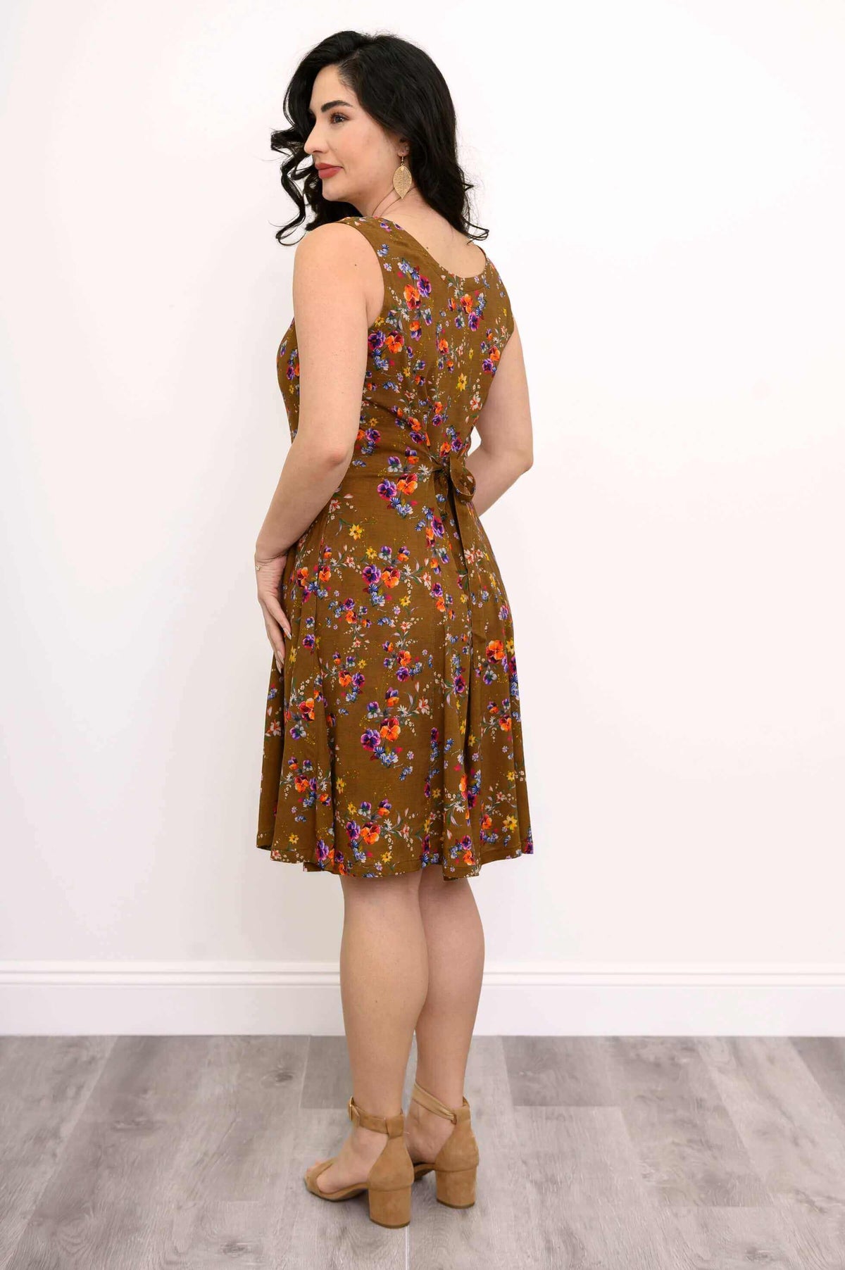 Rear angle of woman showing tie-waist on brown floral A-line dress