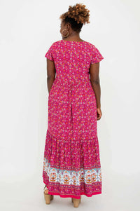 Back view of the pink floral maxi dress with white, blue, and orange border print