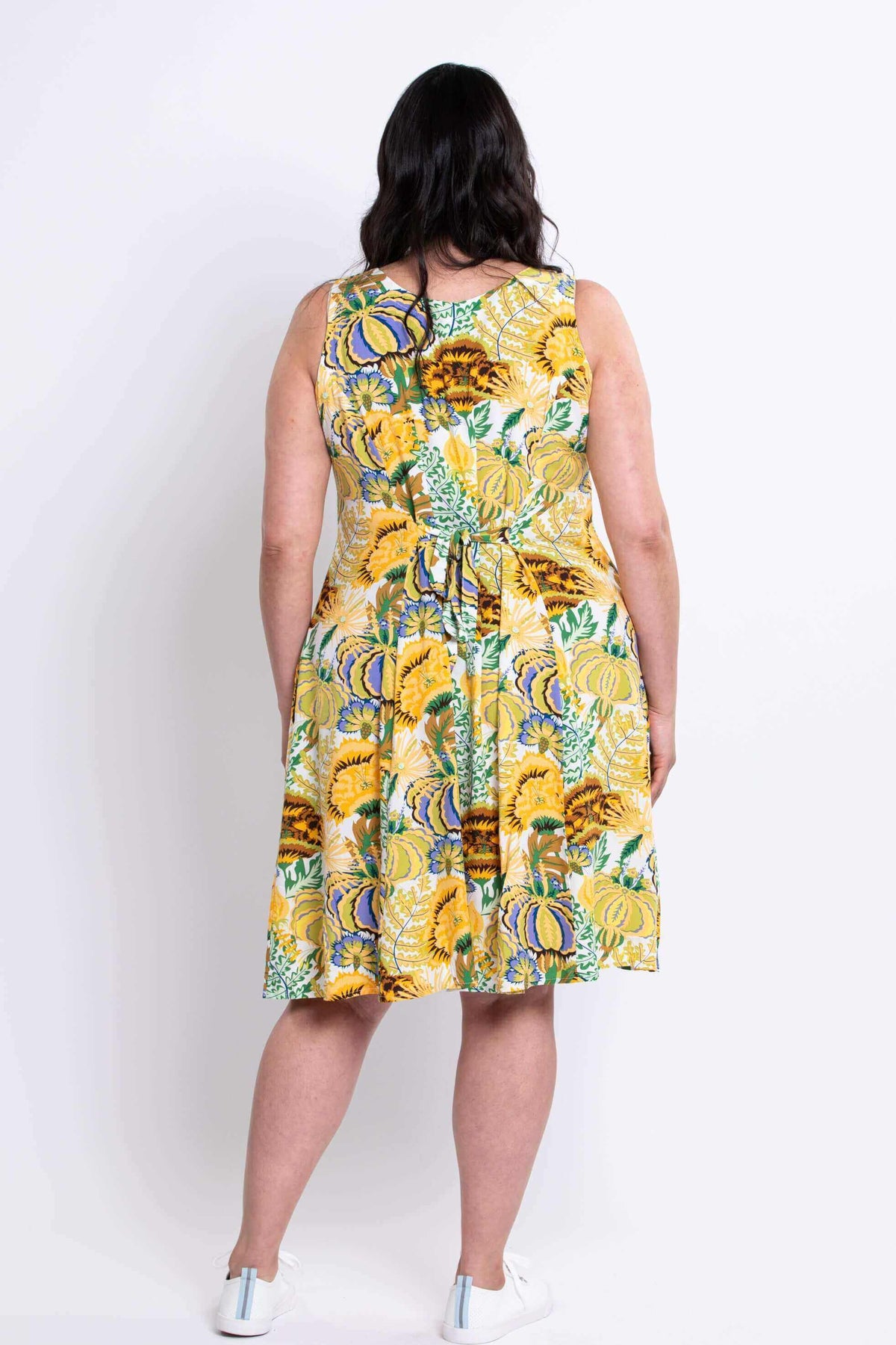 Back view of model in yellow floral summer dress with tie belt detail