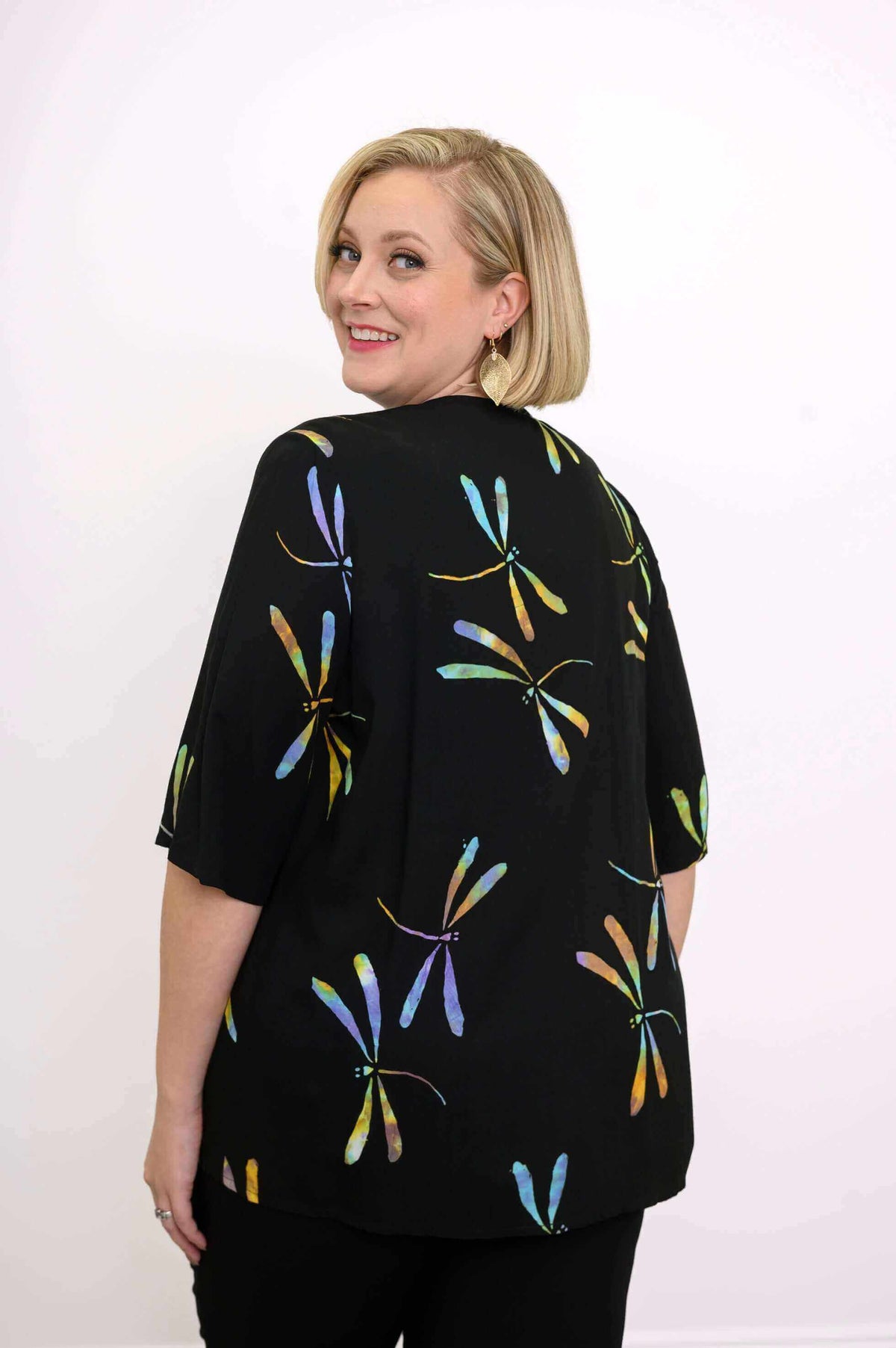 Back view of woman wearing Toucan Dragonfly Jacket with colorful dragonfly pattern