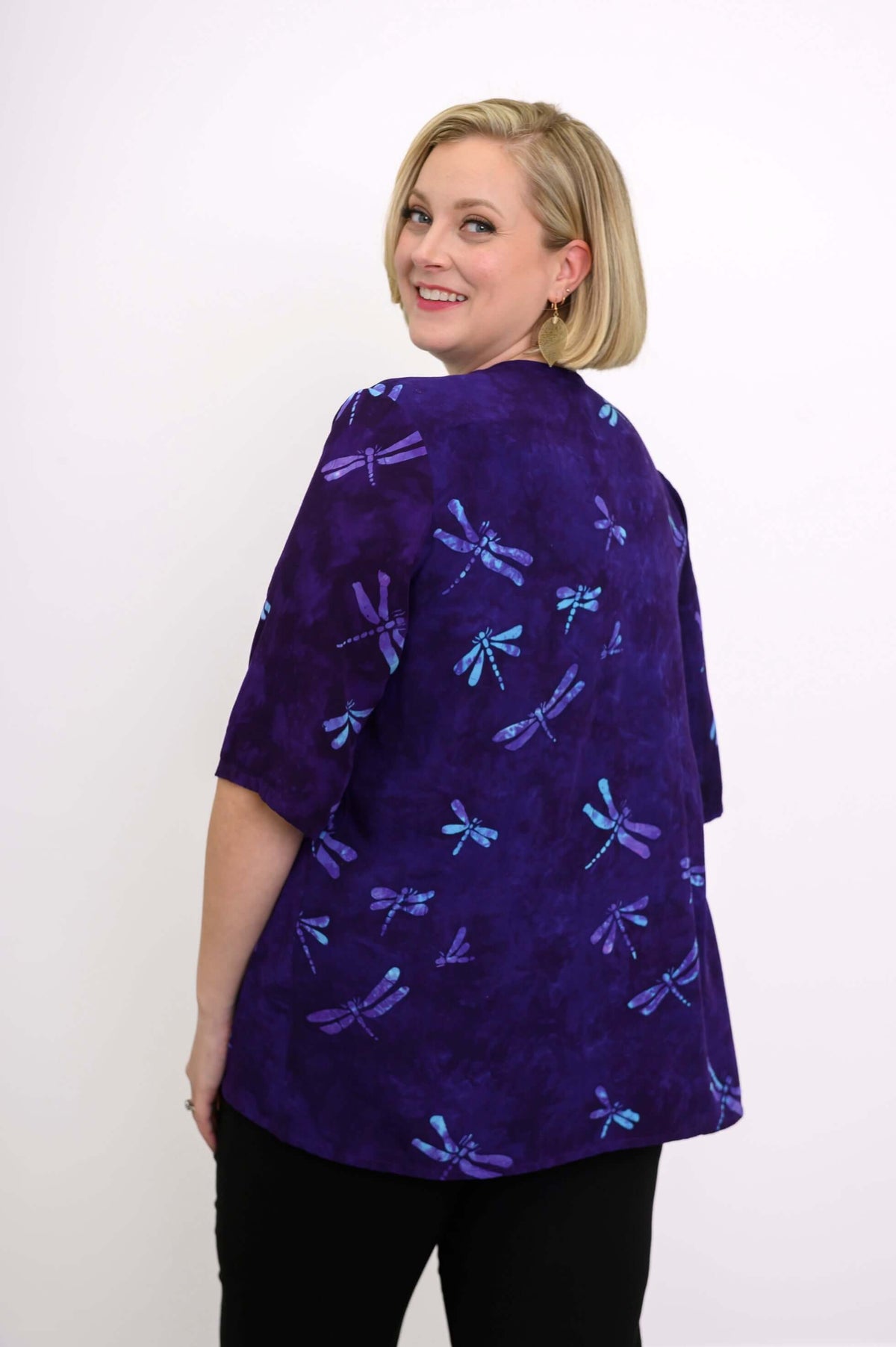 Back view of a woman in a purple jacket with blue dragonfly pattern