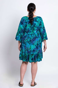 Back view of model showcasing the Wanda dress's flowy fit and ruffled hem