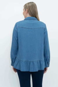 Back view of a blue Tencel denim blouse with ruffled hem worn by a woman