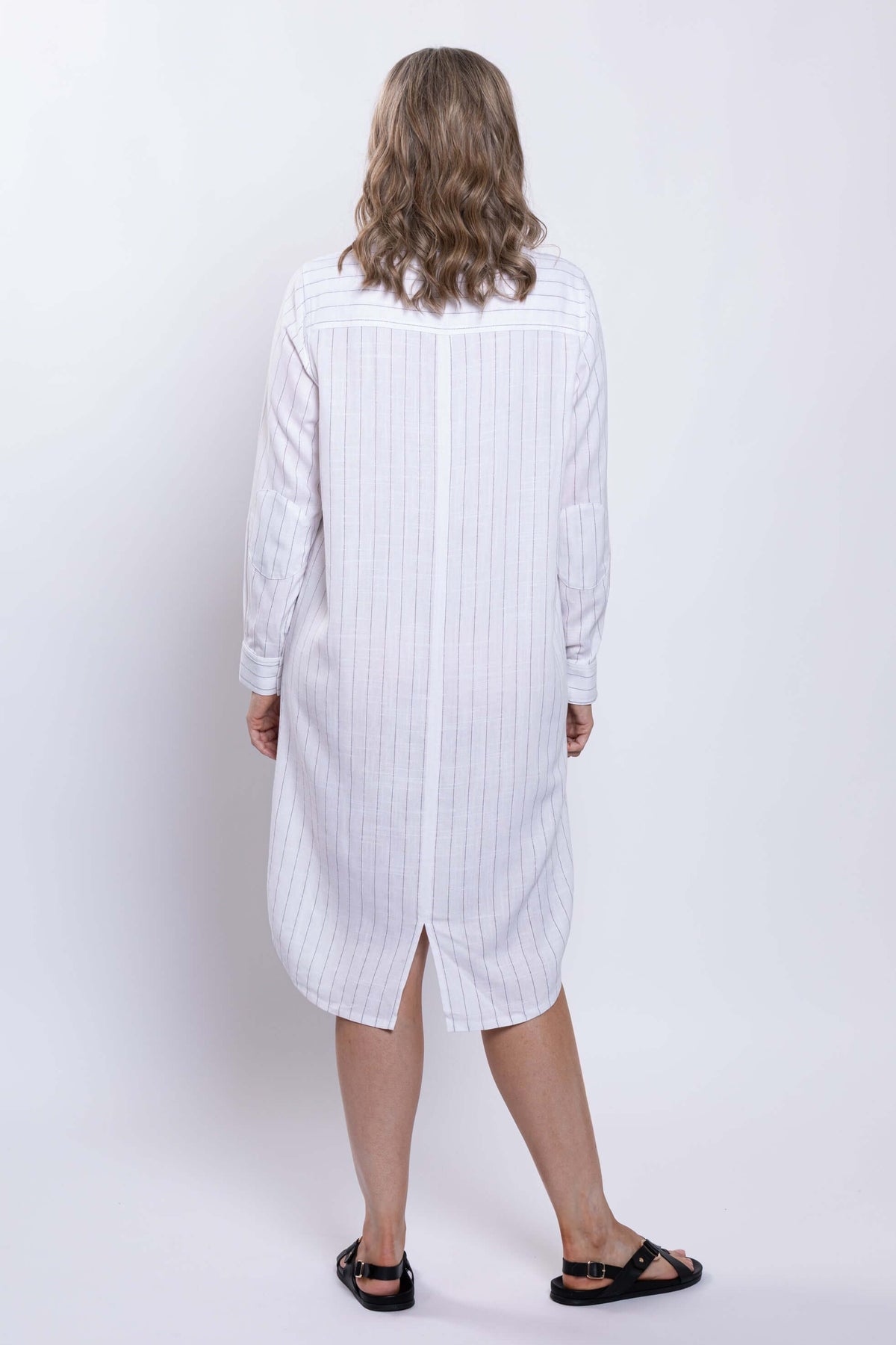 Back view of a white striped shirt dress with center back slit