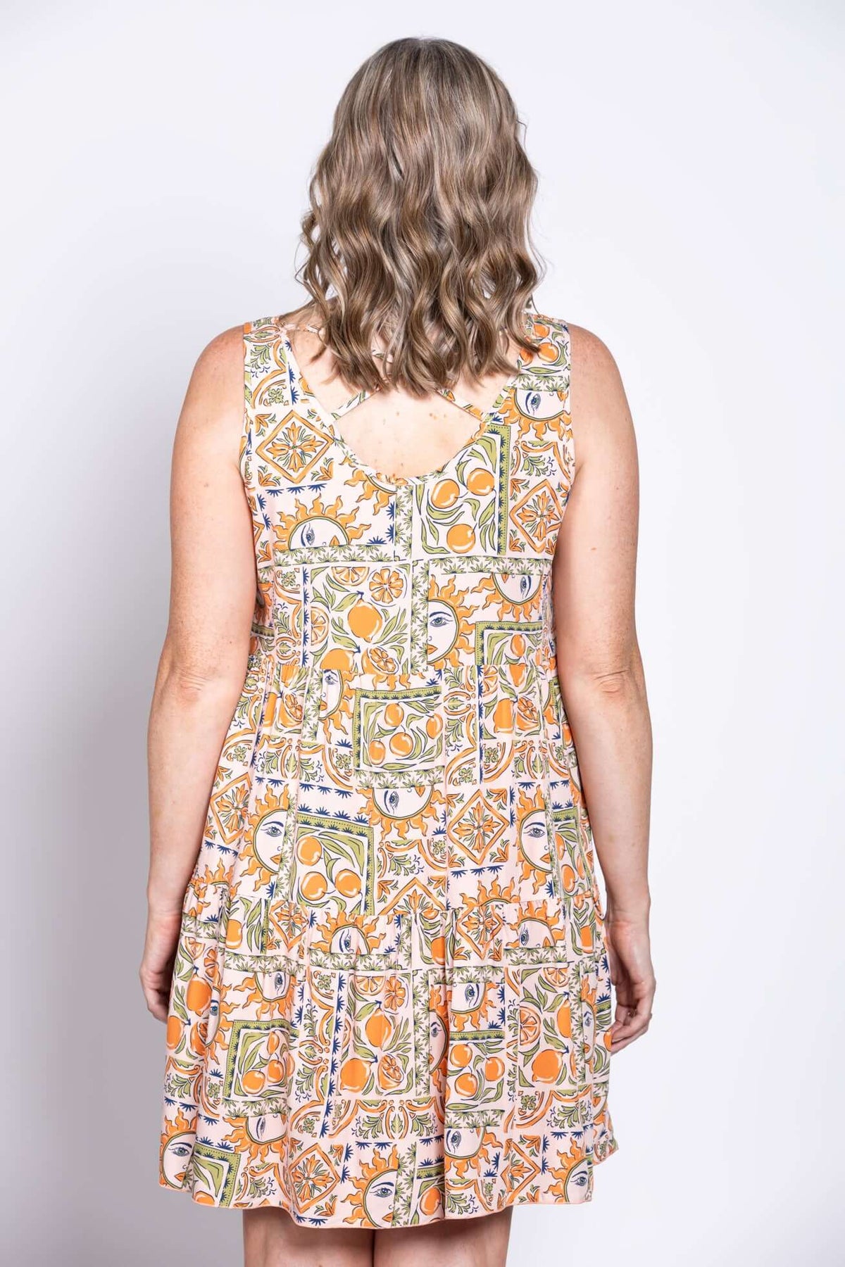 Back view of a woman showing the criss cross detail of a colorful sleeveless dress