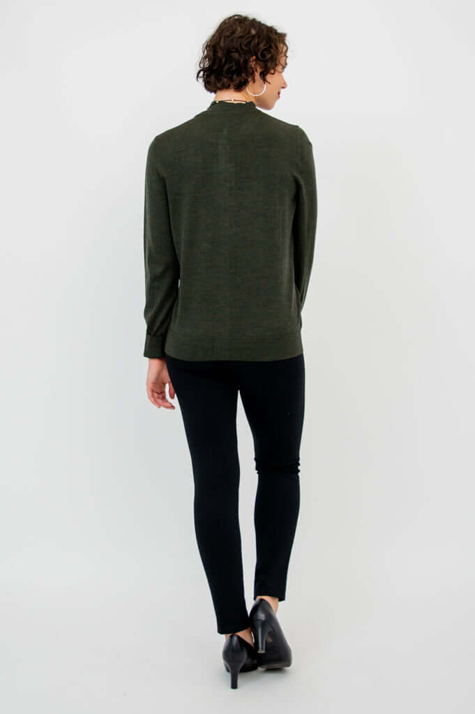 Back view of a woman wearing a dark green merino wool cardigan with long sleeves