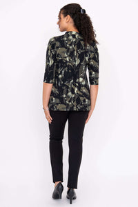 Back view of a woman wearing a black and green abstract pattern top and black pants