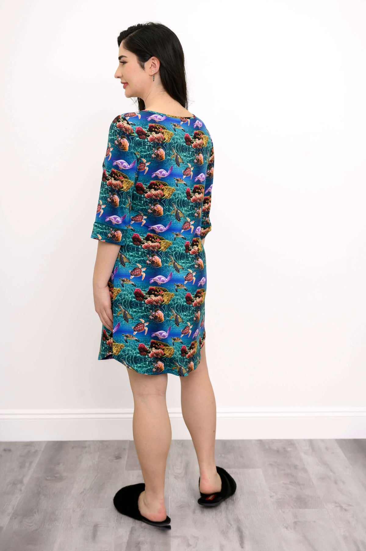Back view of a woman wearing a bamboo sleepshirt with colorful sea life design