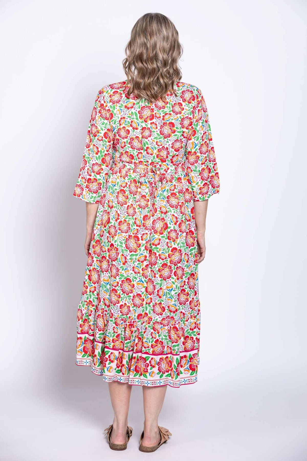 Back view of model wearing floral batik midi dress with waist tie